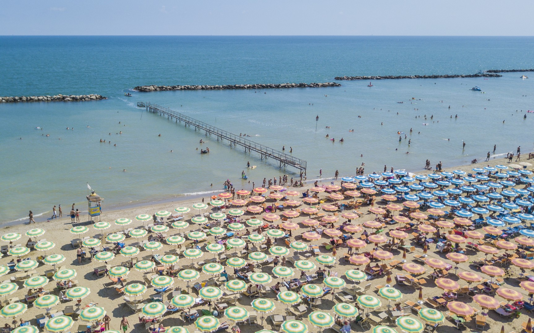 Spiaggia della sabbia fine costellata di ombrelloni e sdraio