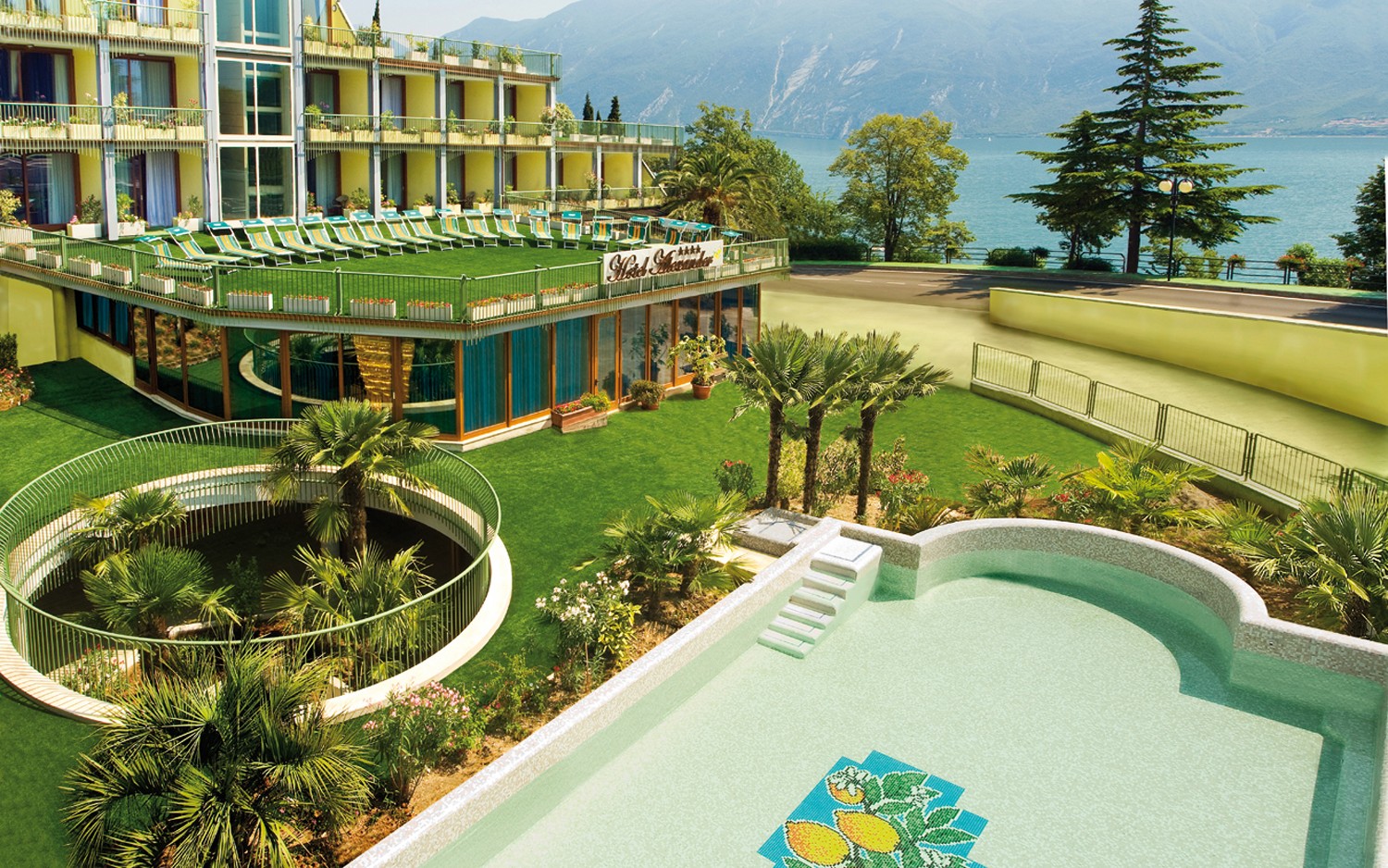 Hotel a Limone sul Garda, tutto giallo e con una bella piscina affrescata circondata da un prato verde.